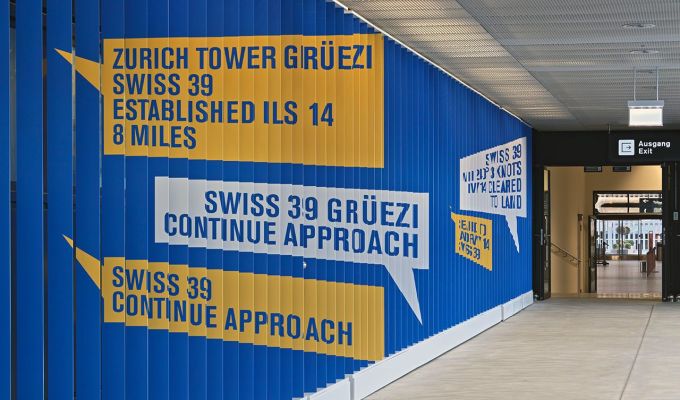 Feststehende Aluminiumlamellen, gebaut und montiert von Colt international, sind die Träger der beiden riesigen Bilder im Zugangskorridor zur neuen Zuschauerterrasse am Dock B des Flughafens Zürich.